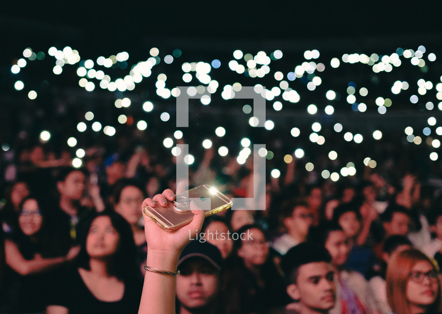 cellphone lights lighting up a concert crowd 