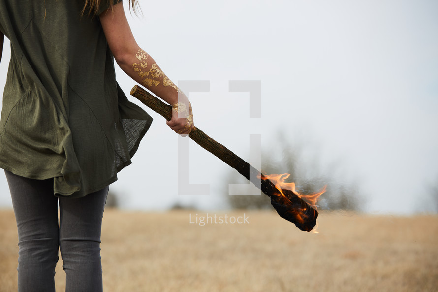 a young woman holding a burning torch 
