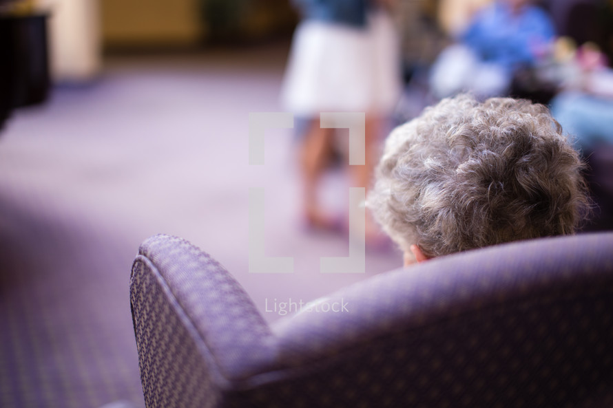 elderly woman sitting in a chair in a nursing home 