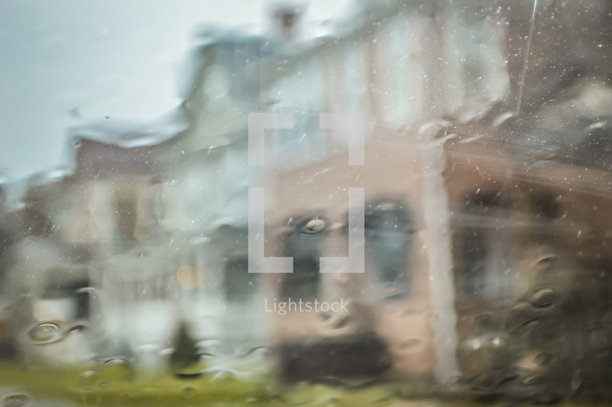 blurry image through a wet window of houses 