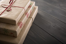 Gifts wrapped in brown paper on a table.