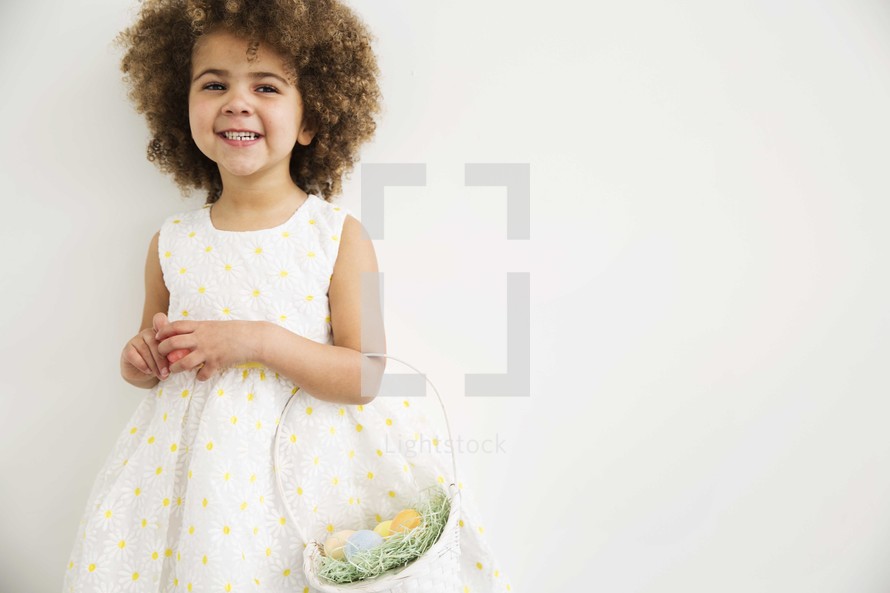 a girl child holding an Easter basket 