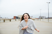 teen girl running in a parking deck 