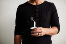 a man holding a blown out candle 