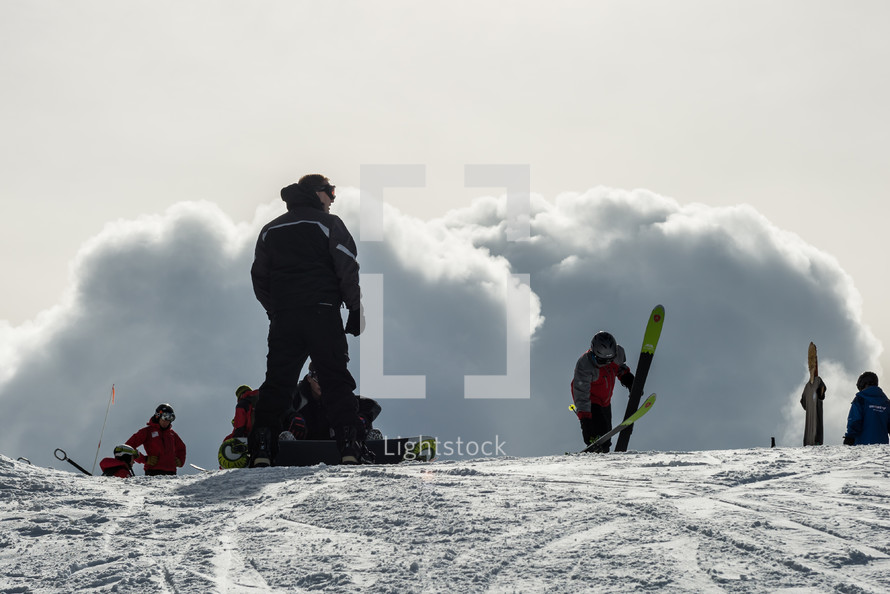 skiers at the top of a slope 