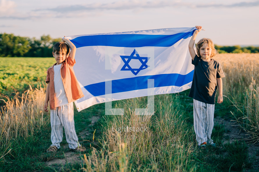 Happy israeli jewish little boys with Israel national flag. Independence Day. Patriotism. Patriot kids, friends on open area field. Symbol of democracy, independence, future. High quality