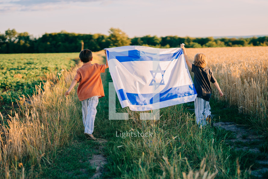 Happy israeli jewish little boys with Israel national flag. Independence Day. Patriotism. Patriot kids, friends on open area field. Symbol of democracy, independence, future. High quality