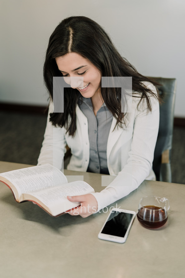 a woman reading a Bible at the office 