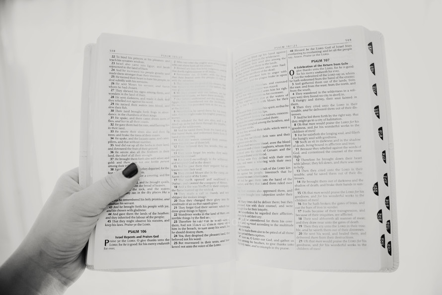 woman holding out an open Bible 