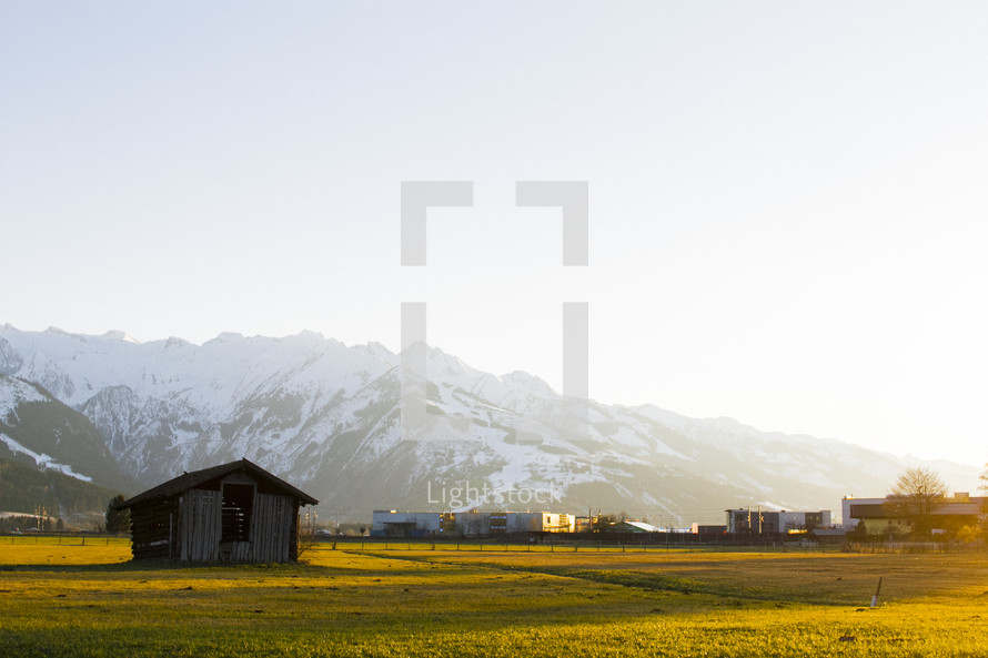 a barn with snow capped mountain backdrop 