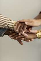 stacked hands in group prayer 