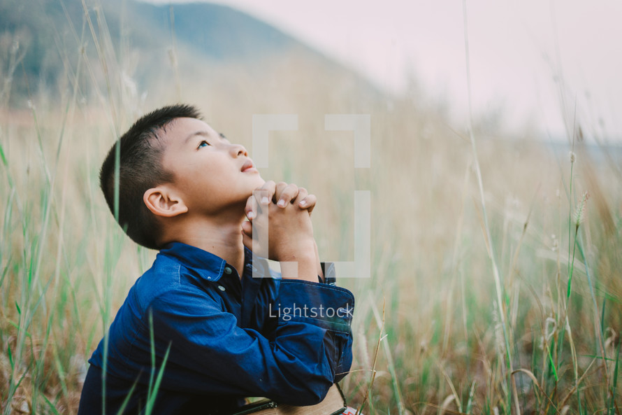 Child looking up to God in prayer 