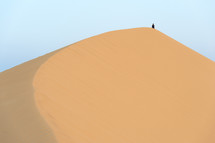 man on top of a sand dune 