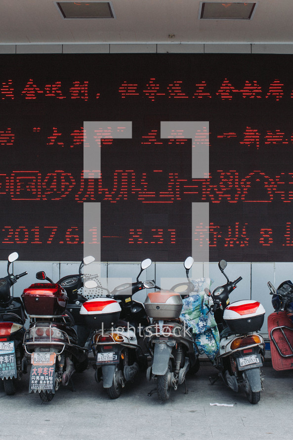 motorcycles parked under Chinese writing 