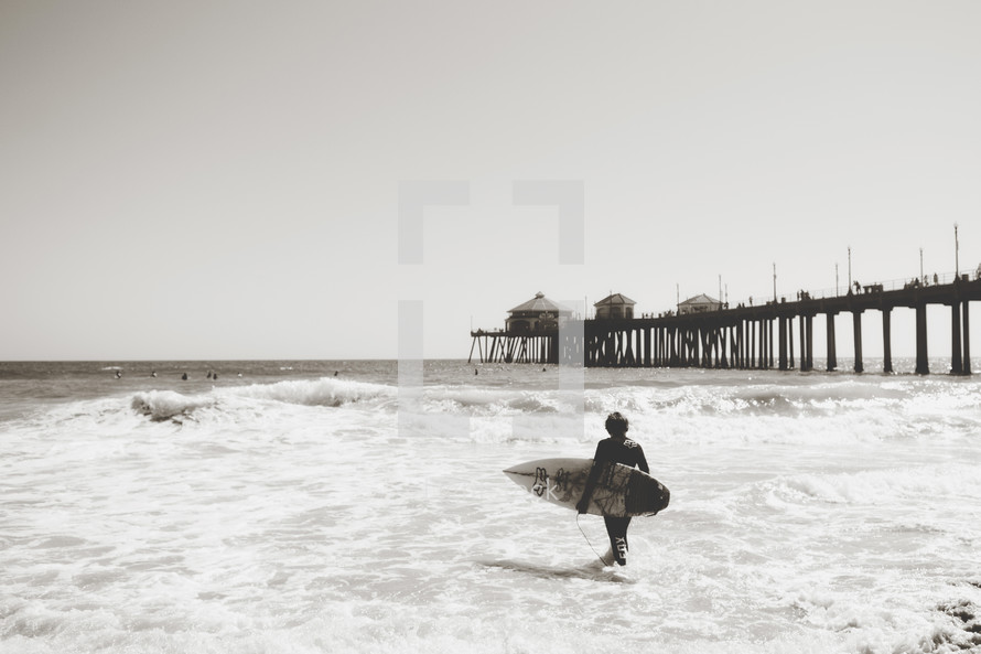 a surfer near a pier 