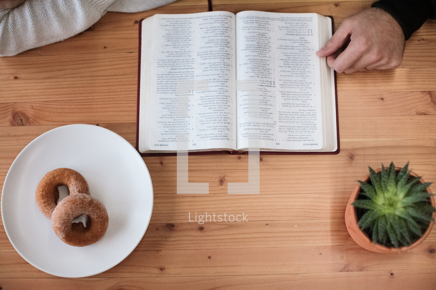 donuts on a plate and a woman reading a Bible 