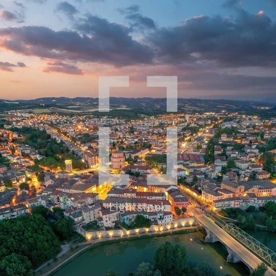 Old italian city Umbertide near Tevere river with cloudy sunset light. Aerial view from above