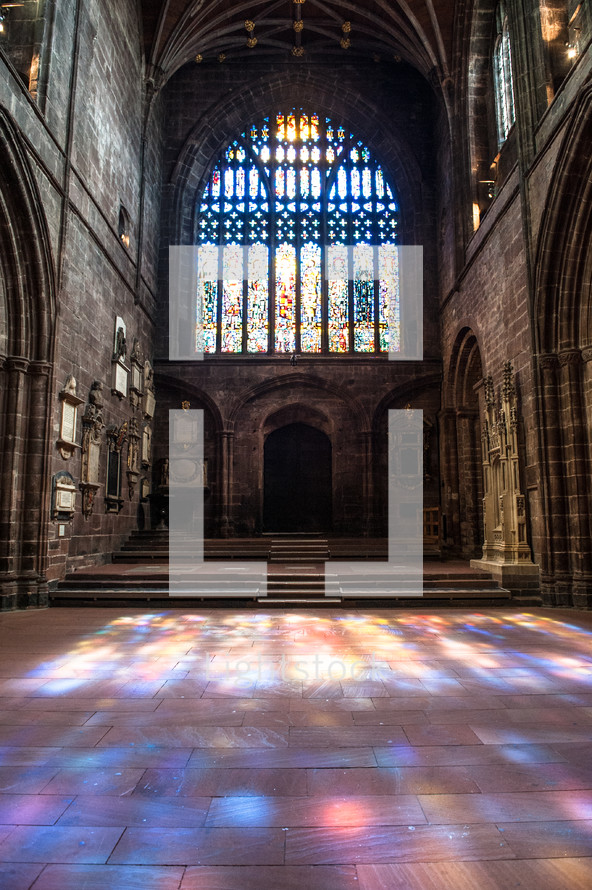 stained glass windows and colorful sunlight on the floor of a church 