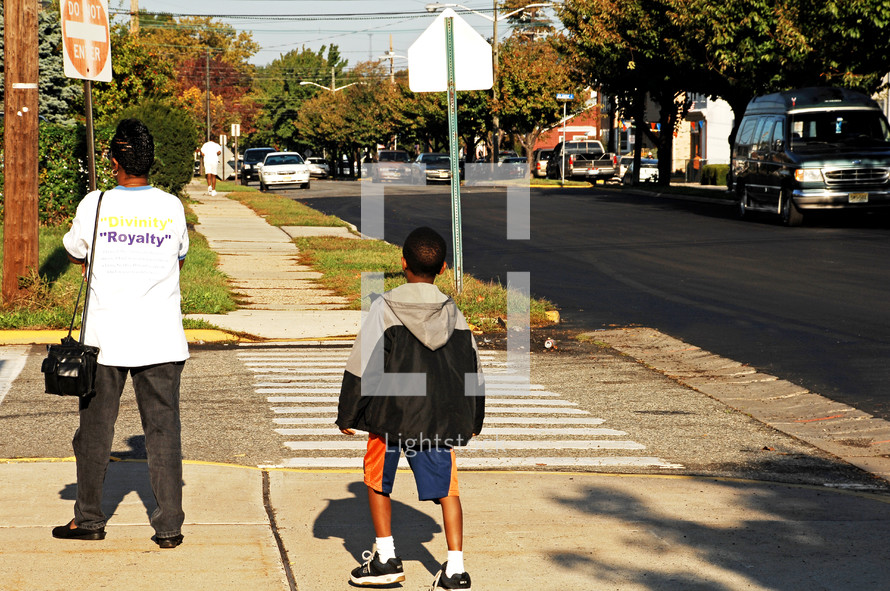 mother and son crossing the street on a crosswalk 