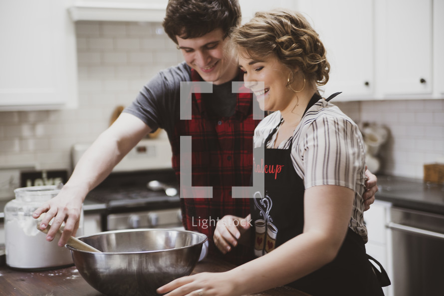 couple baking cookies in a kitchen 