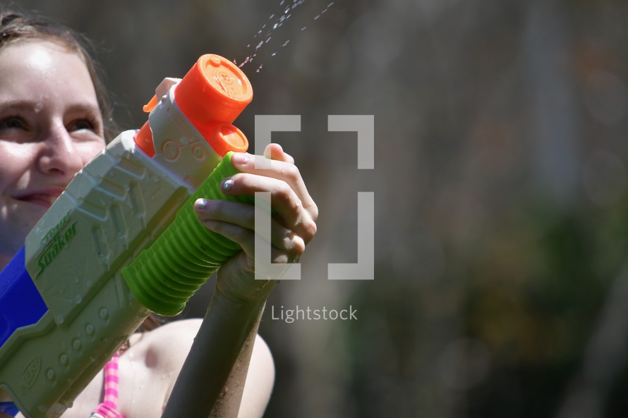 child shooting a water gun 