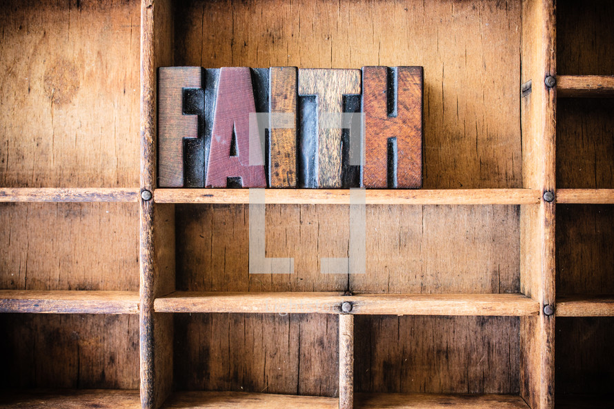 Wooden letters spelling "faith" on a wooden bookshelf.