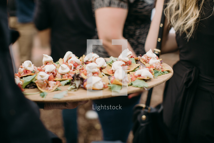 caterer carrying an appetizer tray 