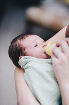 A newborn baby drinking a bottle 