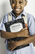 a boy child holding a composition notebook 