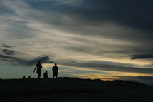 silhouettes of people on a mountain top 