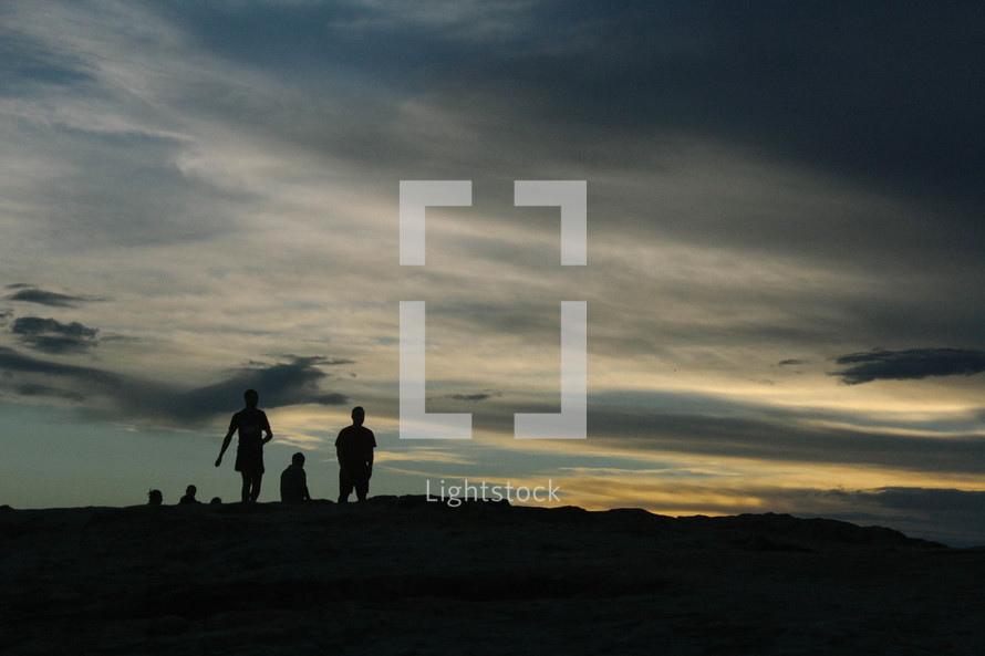 silhouettes of people on a mountain top 