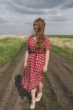young woman alone on a dirt road 