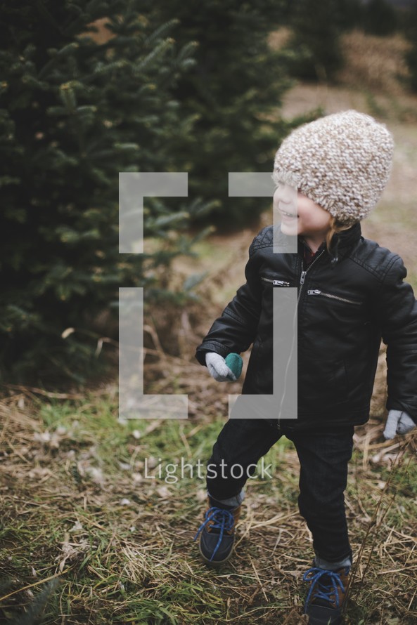 a toddler boy in a Christmas tree lot 