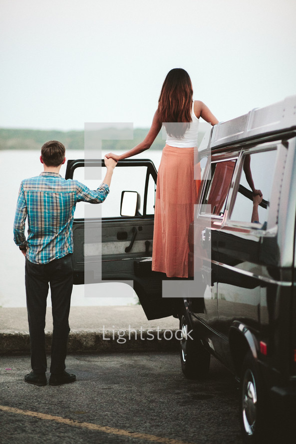 a couple holding hands beside a VW van