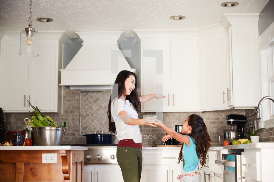 mother and daughter dancing in a kitchen 