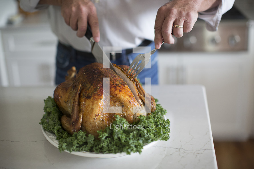 a man carving the Thanksgiving turkey 