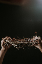 holding up a crown of thorns 