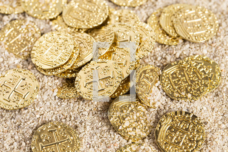 Buried Pirate Treasure Gold Coins in the Sand on a Beach