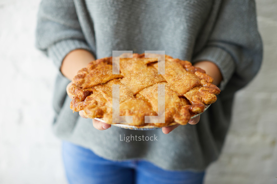 a woman holding a homemade pie 