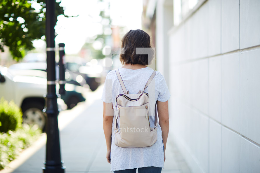 a woman walking down a sidewalk 