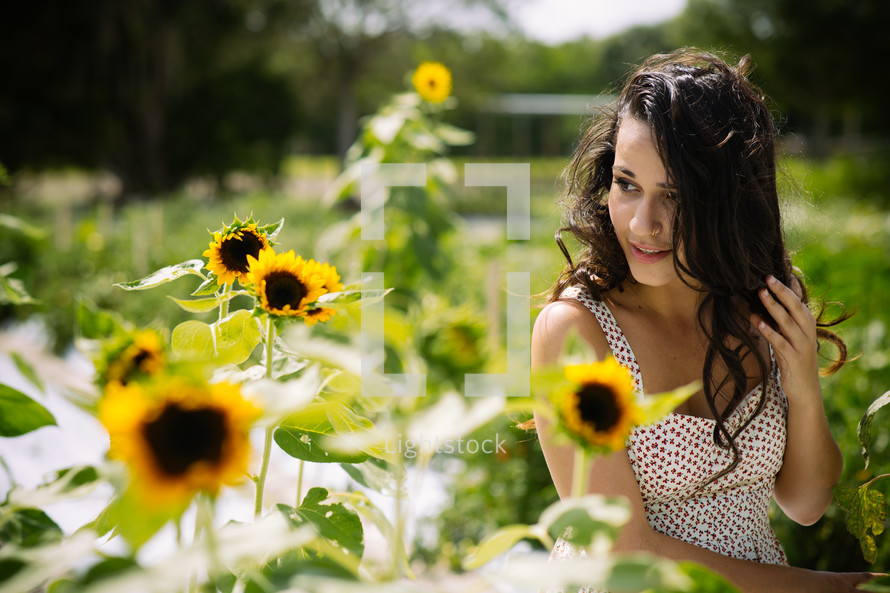 A young woman in a field of sunflowers.