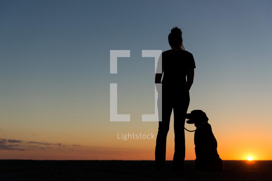 silhouette of a woman and her dog 