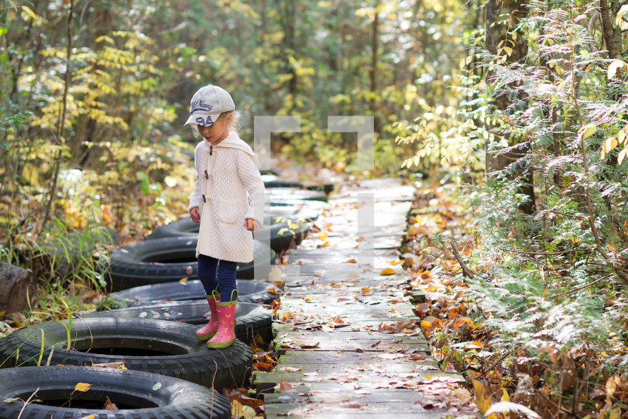 a little girl on a nature trail in fall 