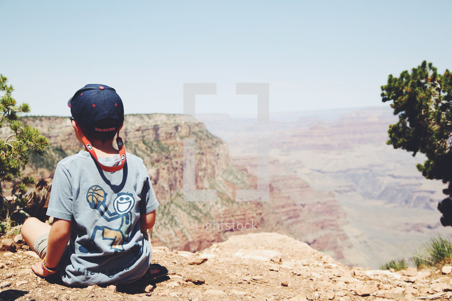 a child looking out at the vastness of the Grand Canyon 