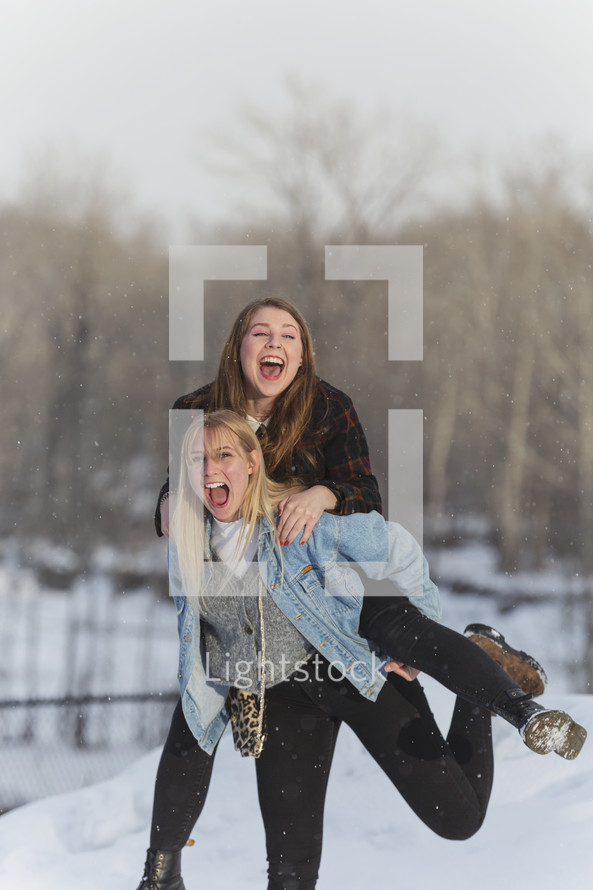 two friends having fun out in snow