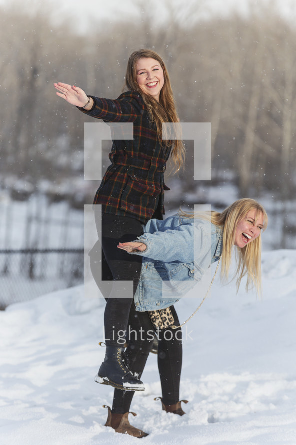 two friends having fun in the snow 