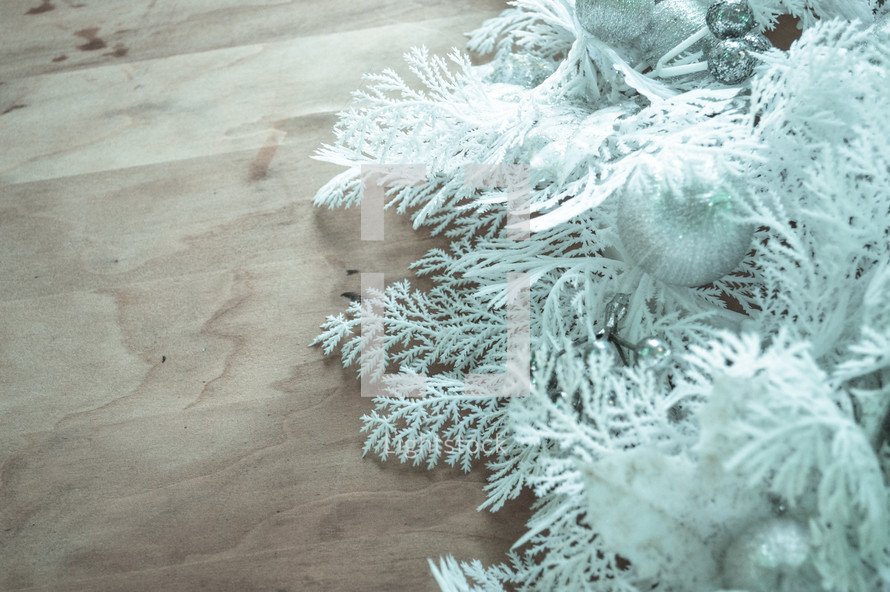 white Christmas greenery on a wood background 