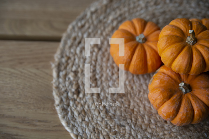 Little pumpkins on braided placemat