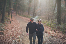 couple walking arm in arm on a nature trail 