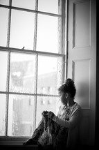 a girl sitting in a window 